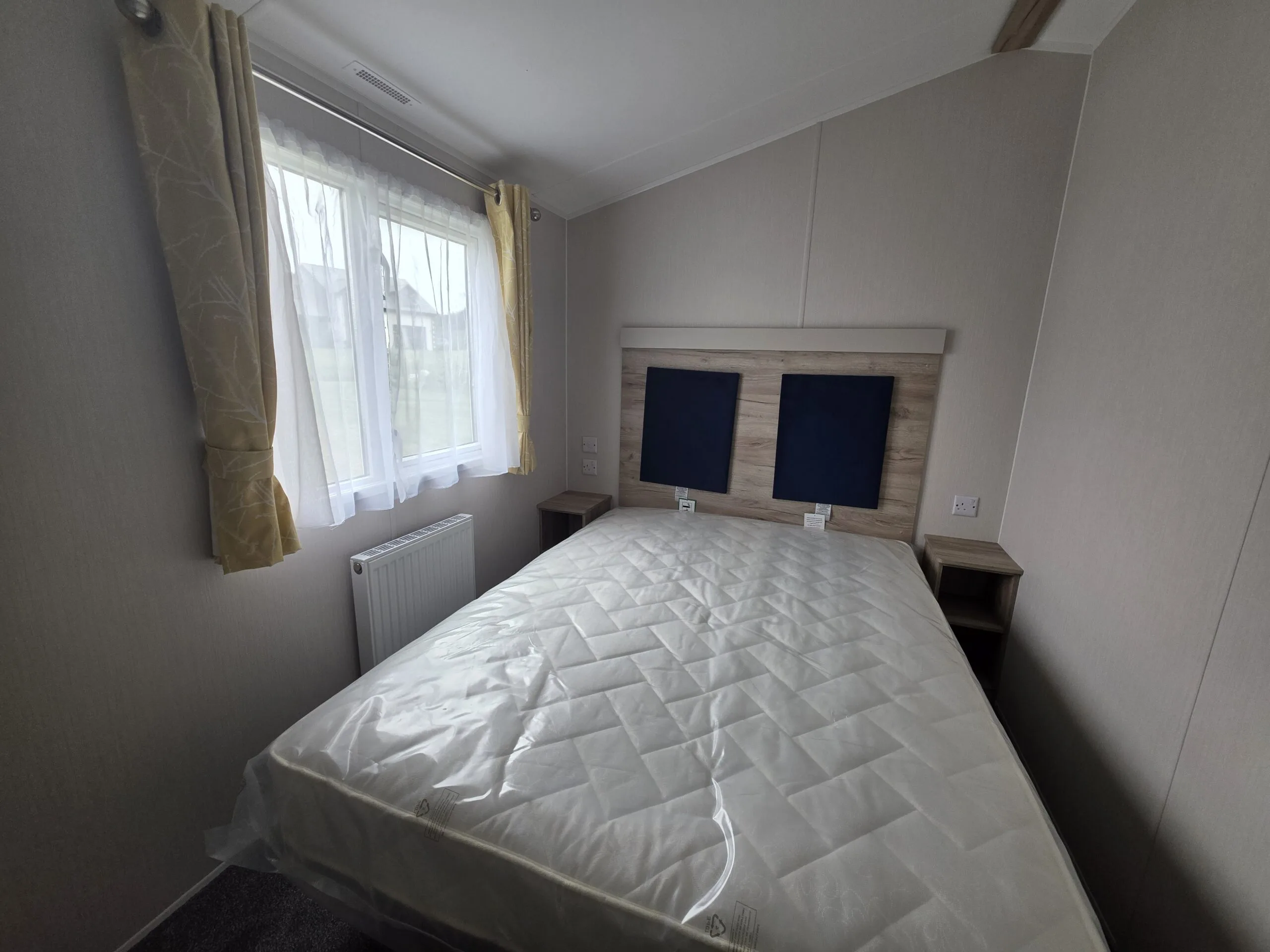 Caravan holiday home bedroom in Cornwall with double bed and window